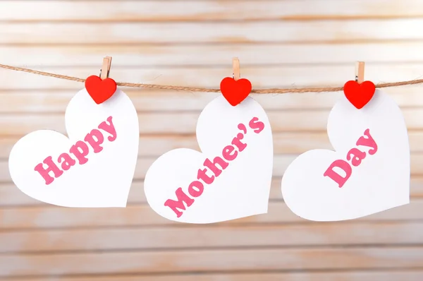 Feliz Dia das Mães mensagem escrita em corações de papel no fundo de luz — Fotografia de Stock