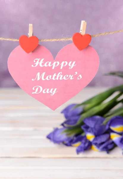 Happy Mothers Day messaggio scritto su cuore di carta con fiori su sfondo viola — Foto Stock