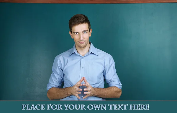 Young teacher near chalkboard in school classroom — Stock Photo, Image