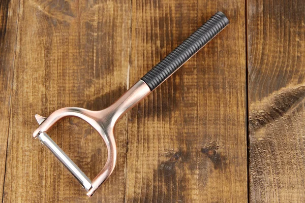 Peeler on wooden background — Stock Photo, Image