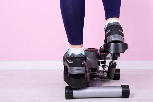 Woman doing exercise on stepper. Close-up on legs. — Stock Photo, Image