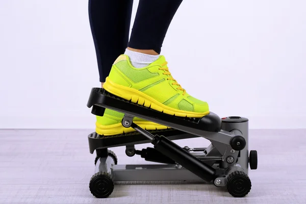 Woman doing exercise on stepper. Close-up on legs. — Stock Photo, Image