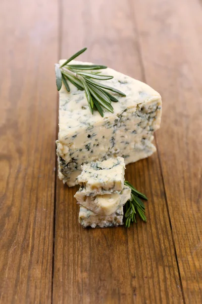 Sabroso queso azul con romero, sobre mesa de madera — Foto de Stock