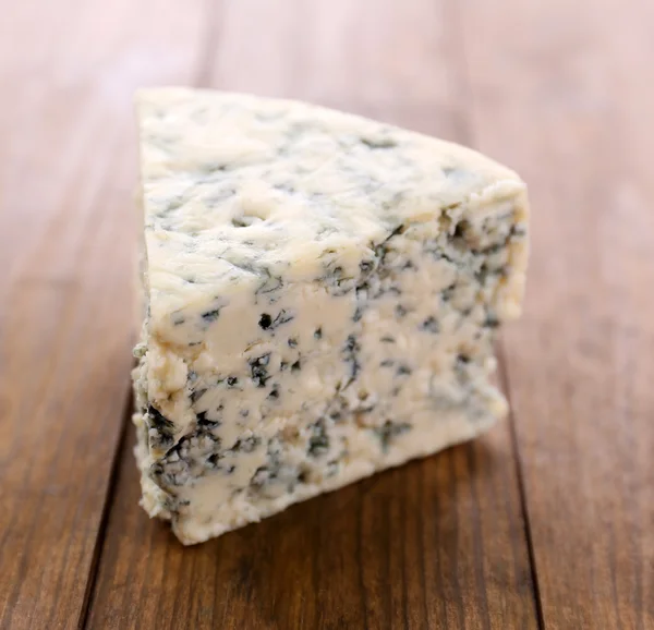 Smakelijke blauwe kaas, op houten tafel — Stockfoto