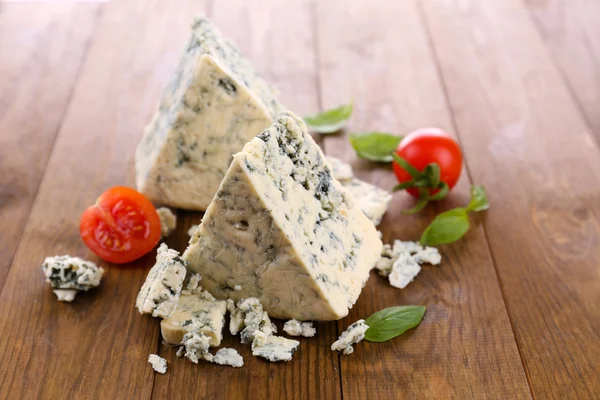 Tasty blue cheese with basil and tomato, on wooden table — Stock Photo, Image