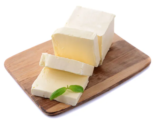 Smakelijke boter op houten snijplank geïsoleerd op wit — Stockfoto