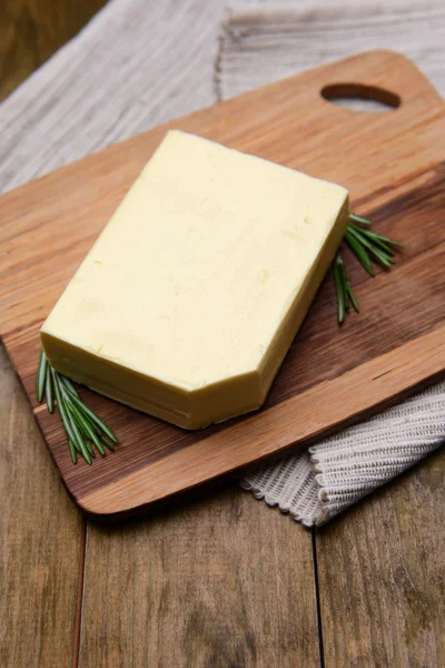 Manteiga saborosa em tábua de corte de madeira — Fotografia de Stock