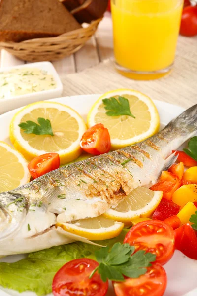 Delicioso pescado a la parrilla en el plato en primer plano de la mesa — Foto de Stock