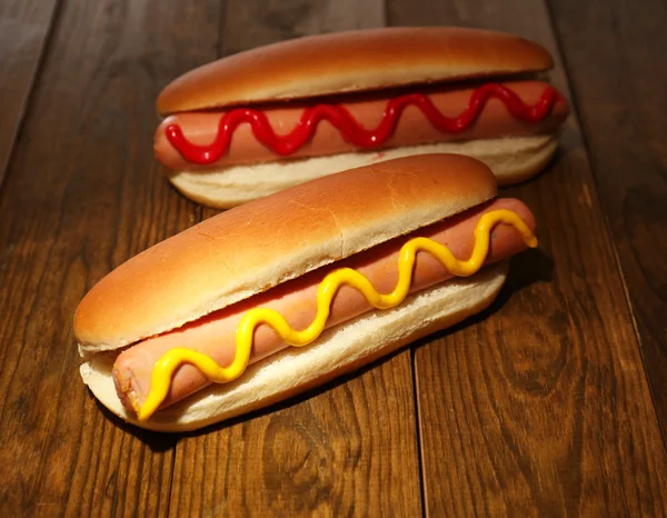 Pyszne hot dogi na drewnianym stole — Zdjęcie stockowe