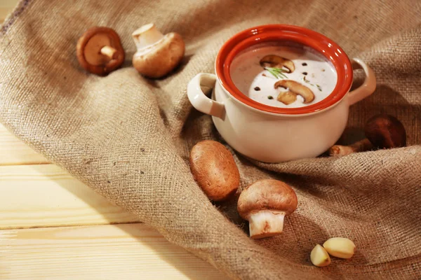 Mushroom soup in pot,on napkin,  on wooden background — Stock Photo, Image