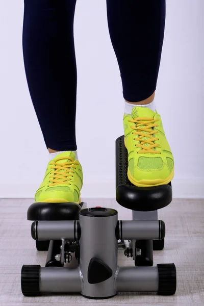 Woman doing exercise on stepper. Close-up on legs. — Stock Photo, Image