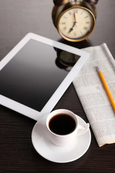 Tableta, periódico, taza de café y despertador en mesa de madera —  Fotos de Stock