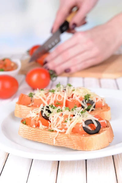 Delicious bruschetta with tomatoes on plate on table close-up — Stock Photo, Image