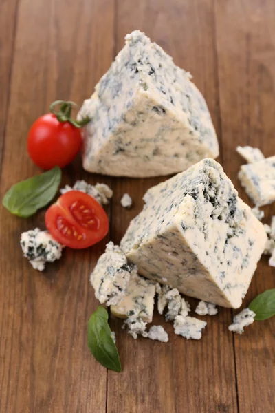 Queijo azul saboroso com manjericão e tomate, sobre mesa de madeira — Fotografia de Stock