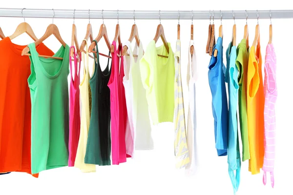 Verschiedene Kleidungsstücke auf Kleiderbügeln, auf grauem Hintergrund — Stockfoto