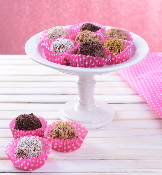 Set von Schokoladenbonbons auf dem Tisch auf rosa Hintergrund — Stockfoto