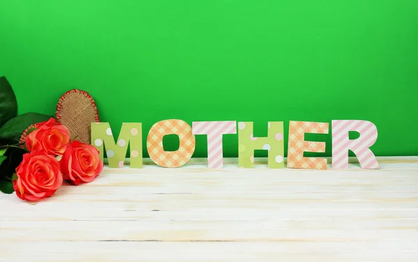 Mother- lettering of handmade paper letters on green background — Stock Photo, Image