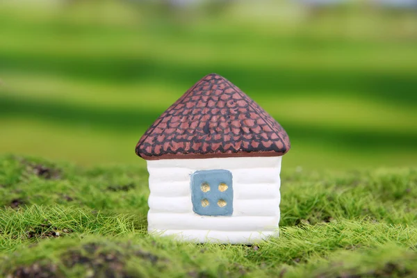 Little house and paper people on green grass, on bright background — Stock Photo, Image