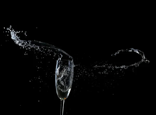 黒の背景にスプラッシュとシャンパンのグラス — ストック写真