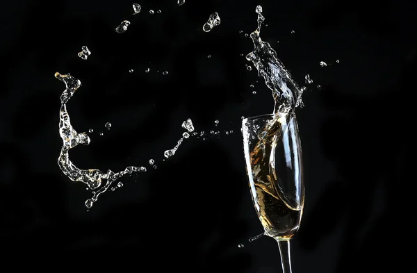 Glas champagne med stänk, på svart bakgrund — Stockfoto