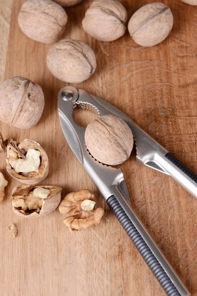 Nussknacker mit Walnüssen auf Holzgrund — Stockfoto