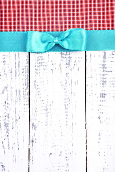 Tissu coloré avec ruban couleur et archet sur fond en bois — Stockfoto