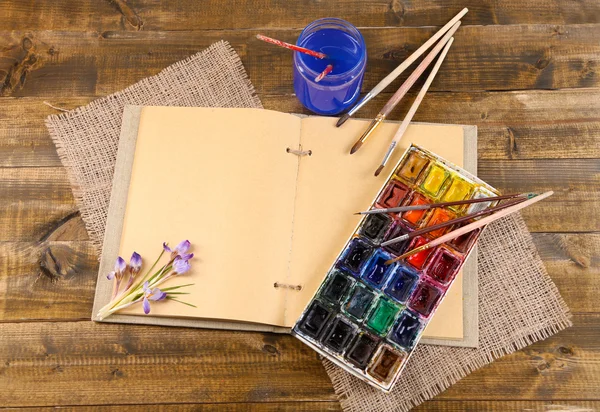 Composición con acuarelas coloridas, pinceles y dibujante sobre fondo de madera —  Fotos de Stock
