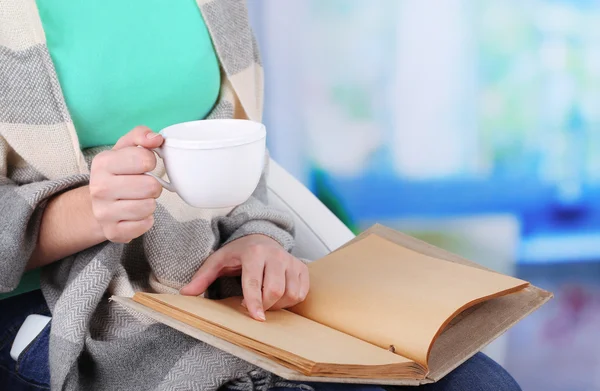 Žena čte knihu a dejte si kávu nebo čaj, detail — Stock fotografie
