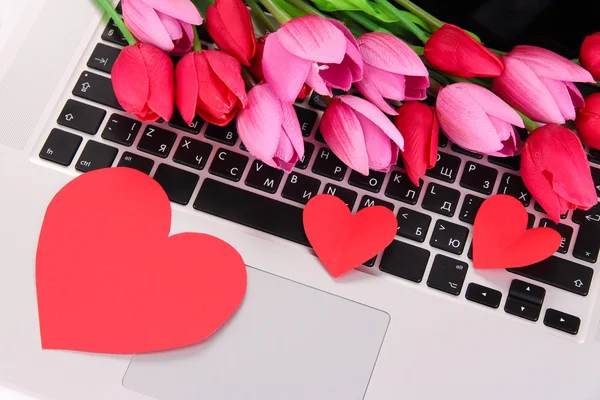 Corazones rojos y flores en el teclado de la computadora de cerca — Foto de Stock