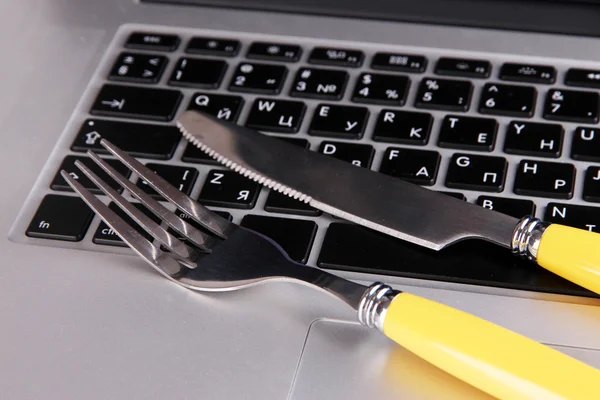 Garfo e faca no teclado do computador de perto — Fotografia de Stock