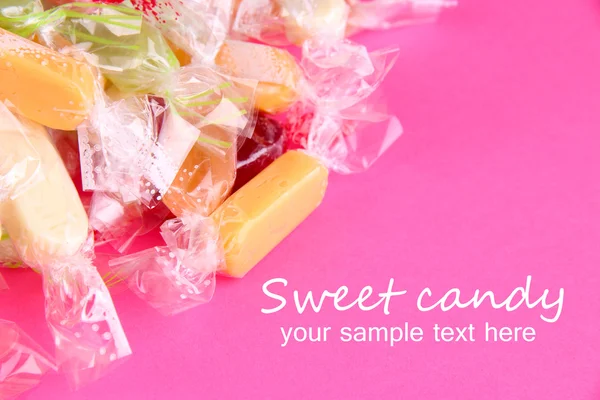 Välsmakande godis på rosa bakgrund — Stockfoto