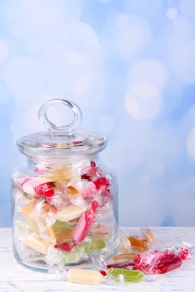 Tasty candies in jar on table on bright background — Stock Photo, Image