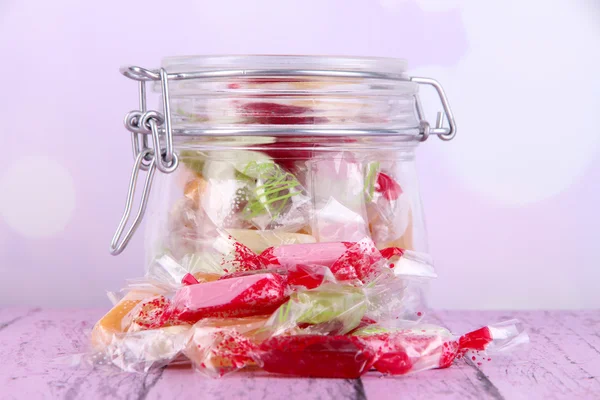 Tasty candies in jar on table on bright background — Stock Photo, Image