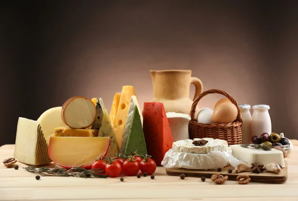 Tasty dairy products on wooden table, on dark background — Stock Photo, Image