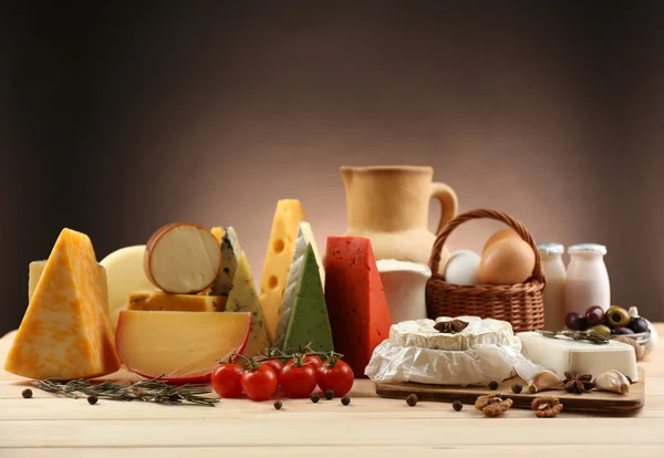 Tasty dairy products on wooden table, on dark background — Stock Photo, Image