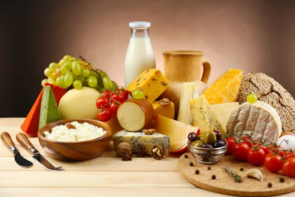 Tasty dairy products on wooden table, on dark background — Stock Photo, Image