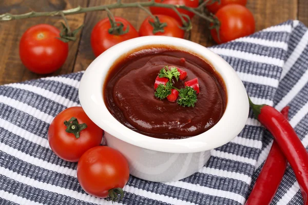 Tomato sauce in bowl on wooden table close-up — Stock Photo, Image