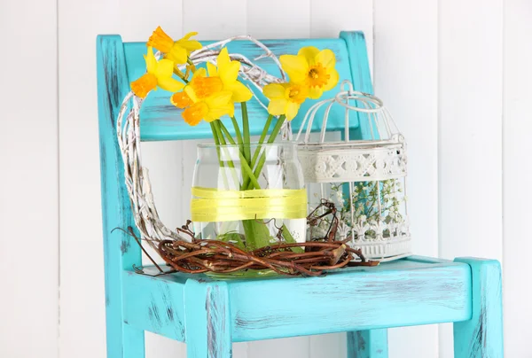 Beautiful spring flowers on blue old wooden chair — Stock Photo, Image