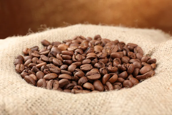 Coffee beans in sack on table close-up — Stock Photo, Image