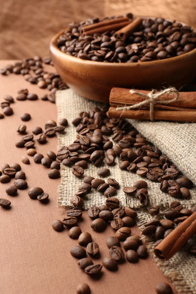 Grains de café sur la table sur fond brun — Photo
