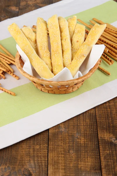 Palitos de pan en canasta de mimbre sobre fondo de madera — Foto de Stock