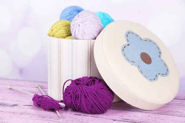 Decorative boxes with colorful skeins of thread on table on bright background — Stock Photo, Image