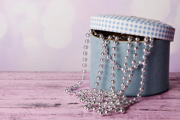 Decorative box with beads on table on bright background — Stock Photo, Image