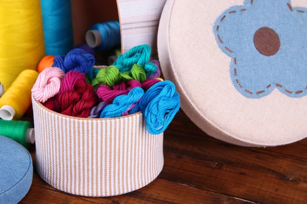 Decorative boxes with colorful skeins of thread on wooden background — Stock Photo, Image