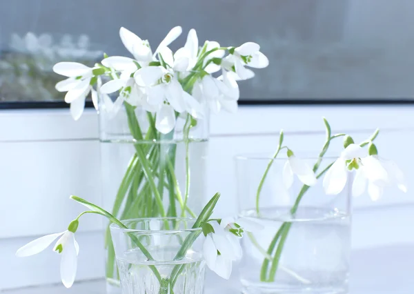 Schöne Sträuße von Schneeglöckchen in Vasen auf der Fensterbank — Stockfoto