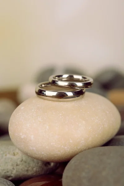 Anéis de casamento em rochas no fundo brilhante — Fotografia de Stock