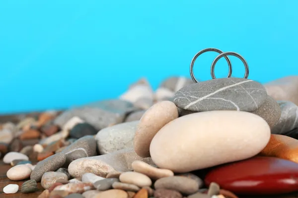 Trauringe auf Felsen auf blauem Hintergrund — Stockfoto