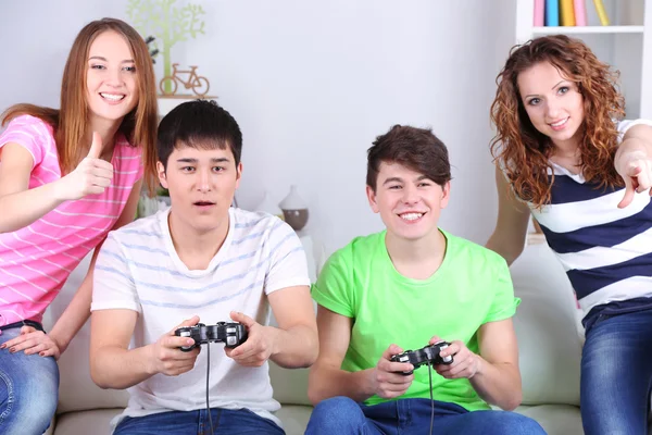 Grupo de jóvenes amigos jugando videojuegos en casa — Foto de Stock