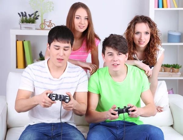 Grupo de jóvenes amigos jugando videojuegos en casa — Foto de Stock