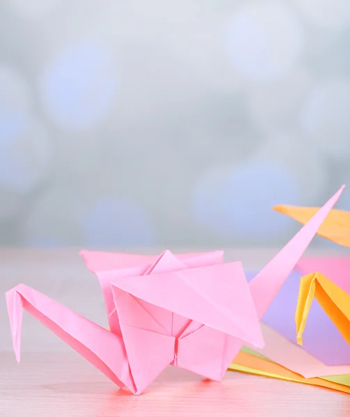 Żurawie origami na drewnianym stole, na jasnym tle — Zdjęcie stockowe